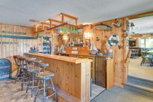 a kitchen with wooden walls and bar stools at Lake Champlain Retreat w/ Dock, Games & More in Willsboro +34 photos