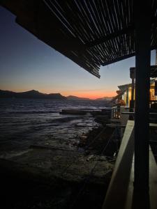 a view of the ocean at sunset from a boat at On The Waves Balcony in Klima