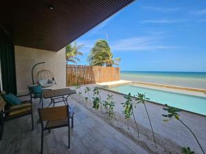 a villa with a pool and a table and chairs at Beachfront , alberca y terraza in Telchac Puerto