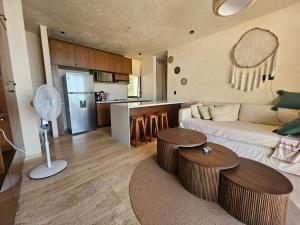 a living room with a couch and tables and a kitchen at Beachfront , alberca y terraza in Telchac Puerto