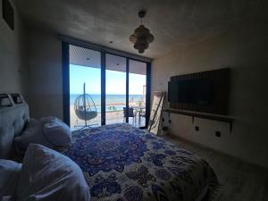 a bedroom with a bed and a view of the ocean at Beachfront , alberca y terraza in Telchac Puerto +27 photos