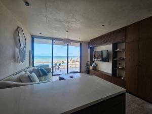 a living room with a view of the beach at Beachfront , alberca y terraza in Telchac Puerto