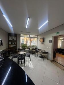 a large room with tables and chairs and a tv at Add Hotéis Center Norte in São Paulo