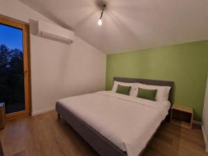 a bedroom with a bed with a green wall at Eiflia- Im Ourtal in Burg-Reuland