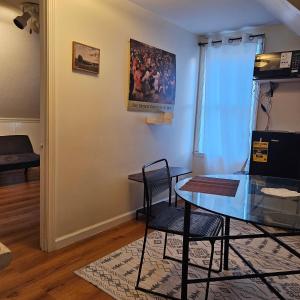 a dining room with a glass table and two chairs at HomeAwayFromHomeMassena in Massena