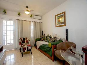 a bedroom with a bed and a couch and a table at Apartamento Rua das Pedras Búzios in Búzios