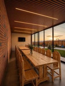 a long wooden table and chairs in a room at Highland Hils in Garni