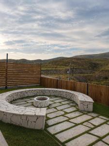 a stone fire pit sitting in the grass at Highland Hils in Garni