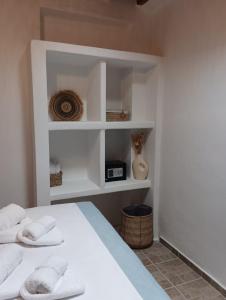 a bedroom with a bed with white shelves at On The Waves Balcony in Klima