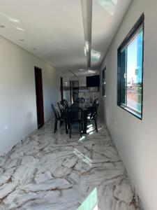 a dining room with a table and chairs on a marble floor at Vila Bangalô in São José da Coroa Grande