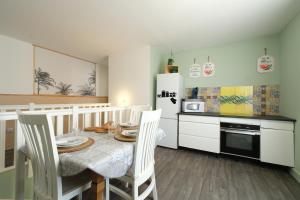 a kitchen with a table and chairs and a refrigerator at La Maison du Bonheur - Appartements & Chambres à Gisors in Gisors