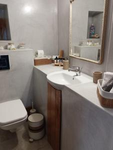 a bathroom with a sink and a toilet and a mirror at On The Waves Balcony in Klima