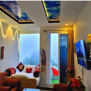 a living room with a couch and a large window at Bhurban Nights - Glass Bed Murree Hills View - Lift - 15 Minutes from Murree & Mallroad in Murree