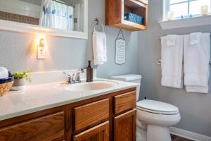 a bathroom with a sink and a toilet and towels at Cozy Cottage in Waco