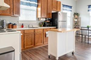 a kitchen with wooden cabinets and a white refrigerator at Cozy Cottage in Waco
