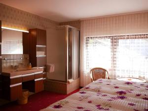 a bedroom with a bed and a sink and a window at Gästehaus Renate in Lauf