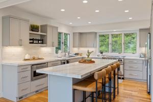 a kitchen with white cabinets and a large island with bar stools at Lone Mountain Lookout in Big Sky