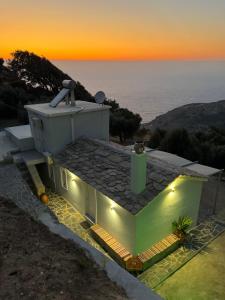 a house with lights on top of it at sunset at Amalour Villa in Amálon