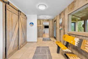 a hallway with a yellow bench and a sliding door at Lone Mountain Lookout in Big Sky