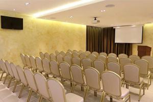 a conference room with a row of chairs and a screen at The District Hotel in Panama City