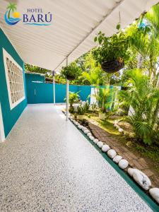 a walkway in front of a building with a roof at Hotel Barú Melgar in Melgar