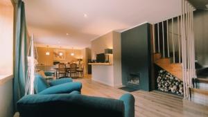 a living room with blue chairs and a fireplace at Quinta de Linhares in Oliveira