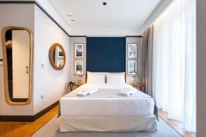 a bedroom with a large white bed and a mirror at Hotel Madeira in Budva +71 photos