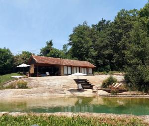 a house on a hill next to a body of water at Quinta de Linhares in Oliveira