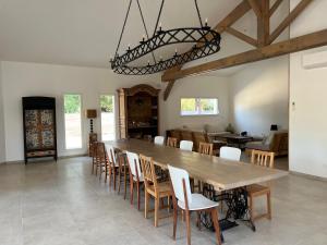 a dining room with a large wooden table and chairs at Gîte du Grand Frêne in Nérac