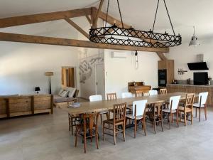 a dining room with a large wooden table and chairs at Gîte du Grand Frêne in Nérac