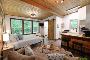 a bedroom with a bed and a living room at Tiny Tarheel Cozy Retreat Near UNC-Tiny House in Chapel Hill