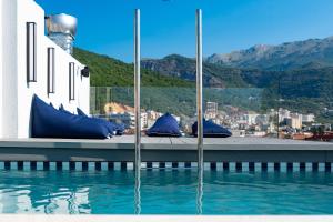 a pool of water with blue pillows on a building at Hotel Madeira in Budva
