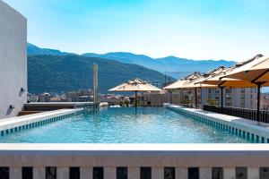 a swimming pool with umbrellas on top of a building at Hotel Madeira in Budva