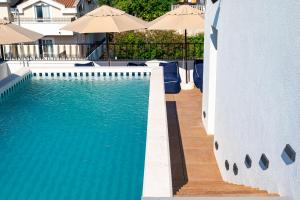 a swimming pool with blue water and umbrellas at Hotel Madeira in Budva