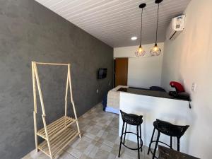a room with two chairs and a bar with a bed at Aura Mar Flat in Baía Formosa