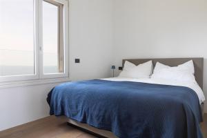 a bedroom with a bed with a blue blanket and a window at Villa Francesca Toscolano in Toscolano Maderno +22 photos