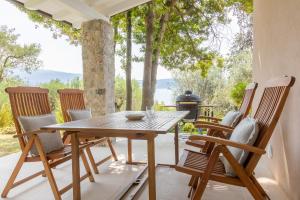 a wooden table and chairs on a patio with a grill at Villa Francesca Toscolano in Toscolano Maderno
