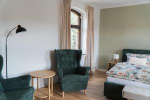 a bedroom with a bed and a chair and a table at "LOKAL" Apartment 2 in Bad Muskau