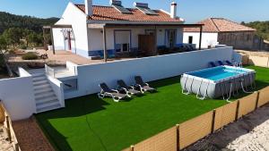 a house with a swimming pool on a lawn at Monte da Caniveta - Casa dos Compadres in São Luis