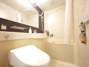 a bathroom with a white toilet and a sink at APA Hotel Tonami Ekimae in Tonami