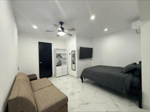 a bedroom with a bed and a couch in it at Lujoso departamento con alberca y jacuzzi in Monterrey