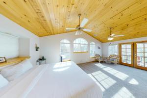 a bedroom with a large bed with a wooden ceiling at Brier Escape in Bass Lake