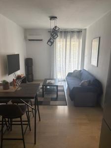 a living room with a blue couch and a table at Nenas house in Porto Rafti