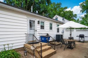 a patio with a table and an umbrella next to a house at Cozy Corner in Terre Haute