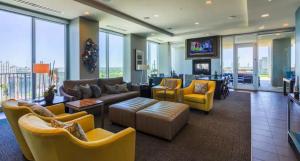 a living room with yellow furniture and a tv at SE Furnished Apartment in Atlanta