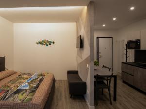 a bedroom with a bed and a desk and a table at A 2 min dal Trenino Rosso Monolocale CLESSIDRA1 in Tirano