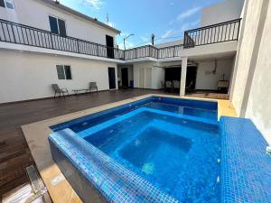 a large blue swimming pool in front of a house at Lujoso departamento con alberca y jacuzzi in Monterrey