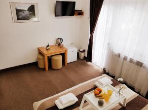 a living room with a desk and a table with fruit on it at Guest House Kovačević in Korenica