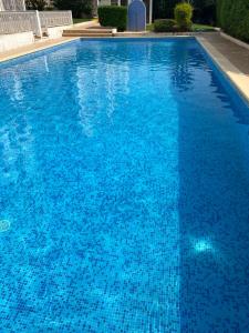 a large blue swimming pool with blue water at Apartamento Oceano in Albufeira