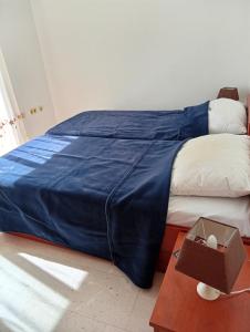 a bed with a blue comforter and a box on a table at Dobrila in Slano